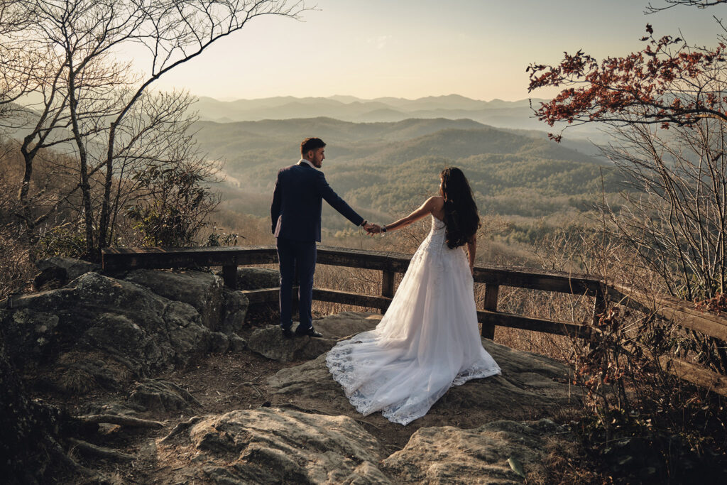 Couple holding hands on a mountaintop.