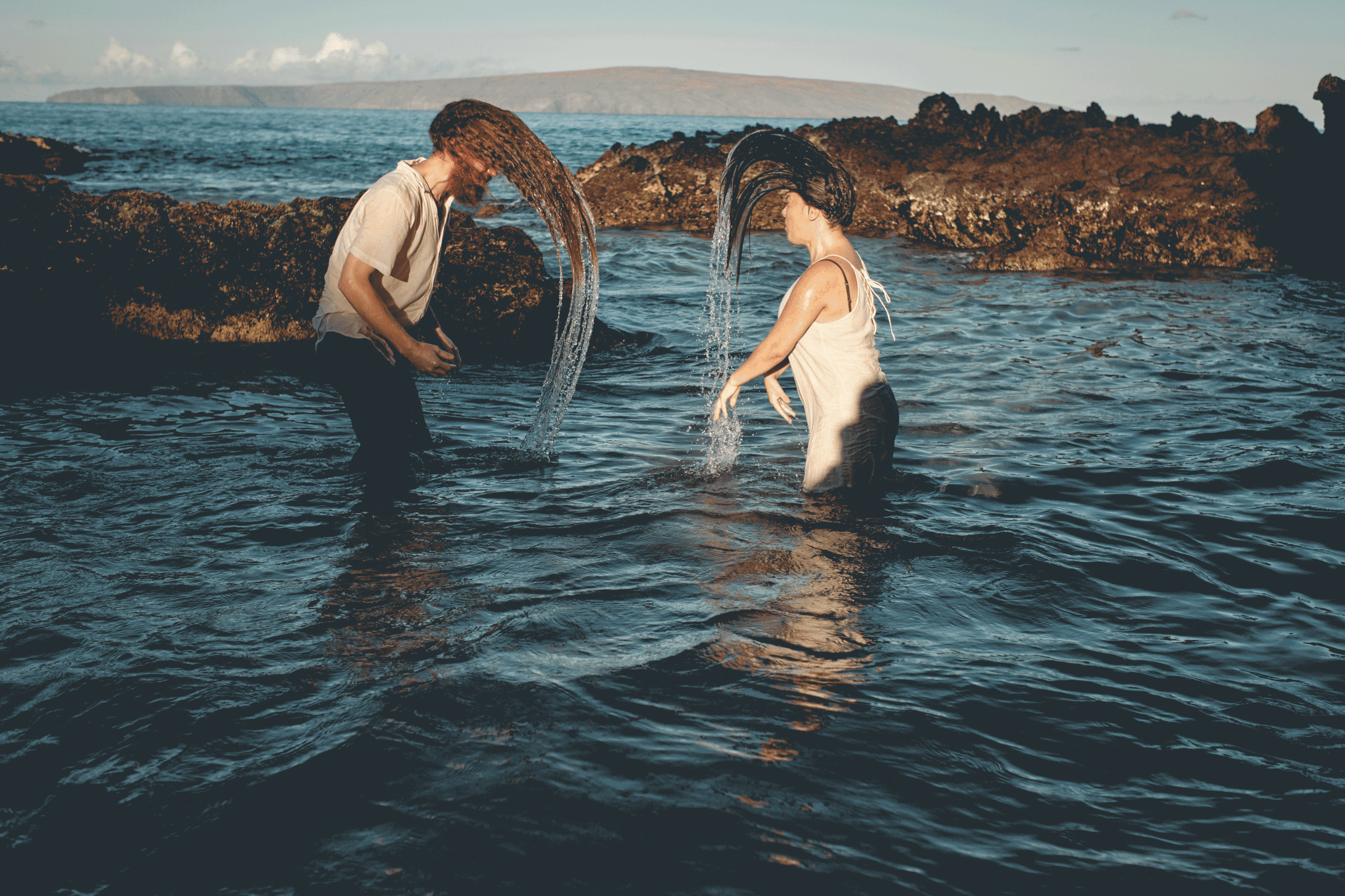 Couple flipping their hair in the water to prove that you can do whatever you want on your elopement day.