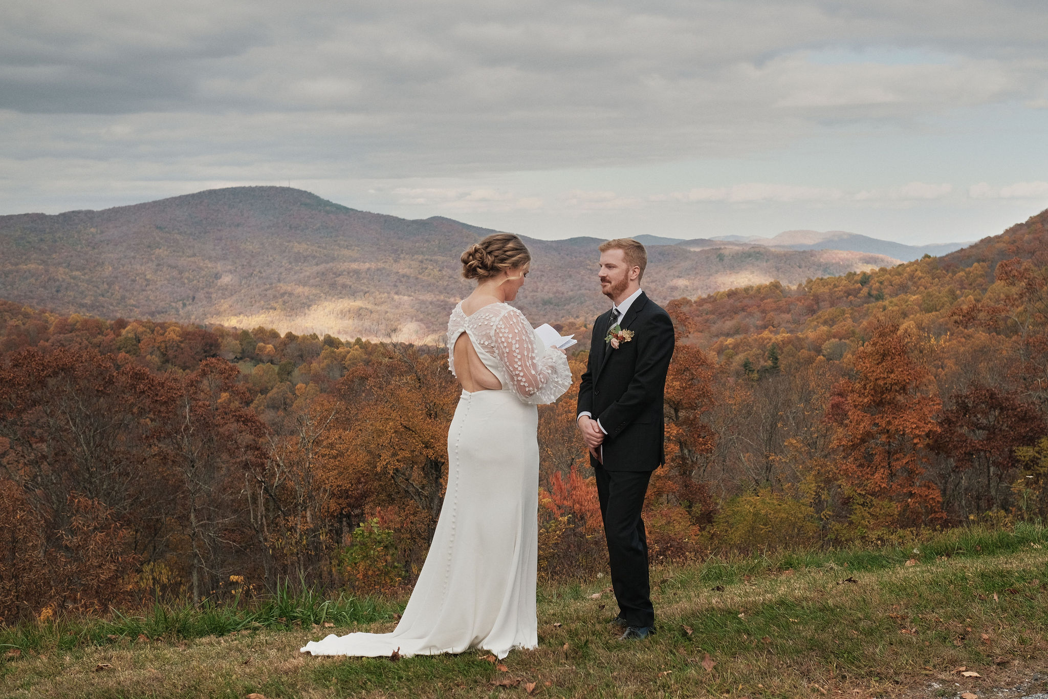 Eloping couple saying their vows to each other with the mountains in the background