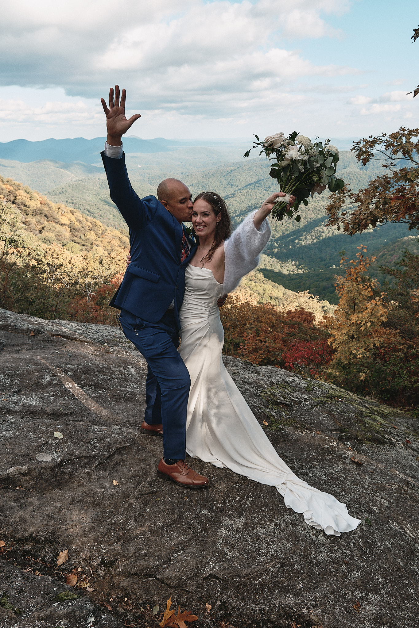 Couple is excited about their choice to elope and is throwing their hands in the air