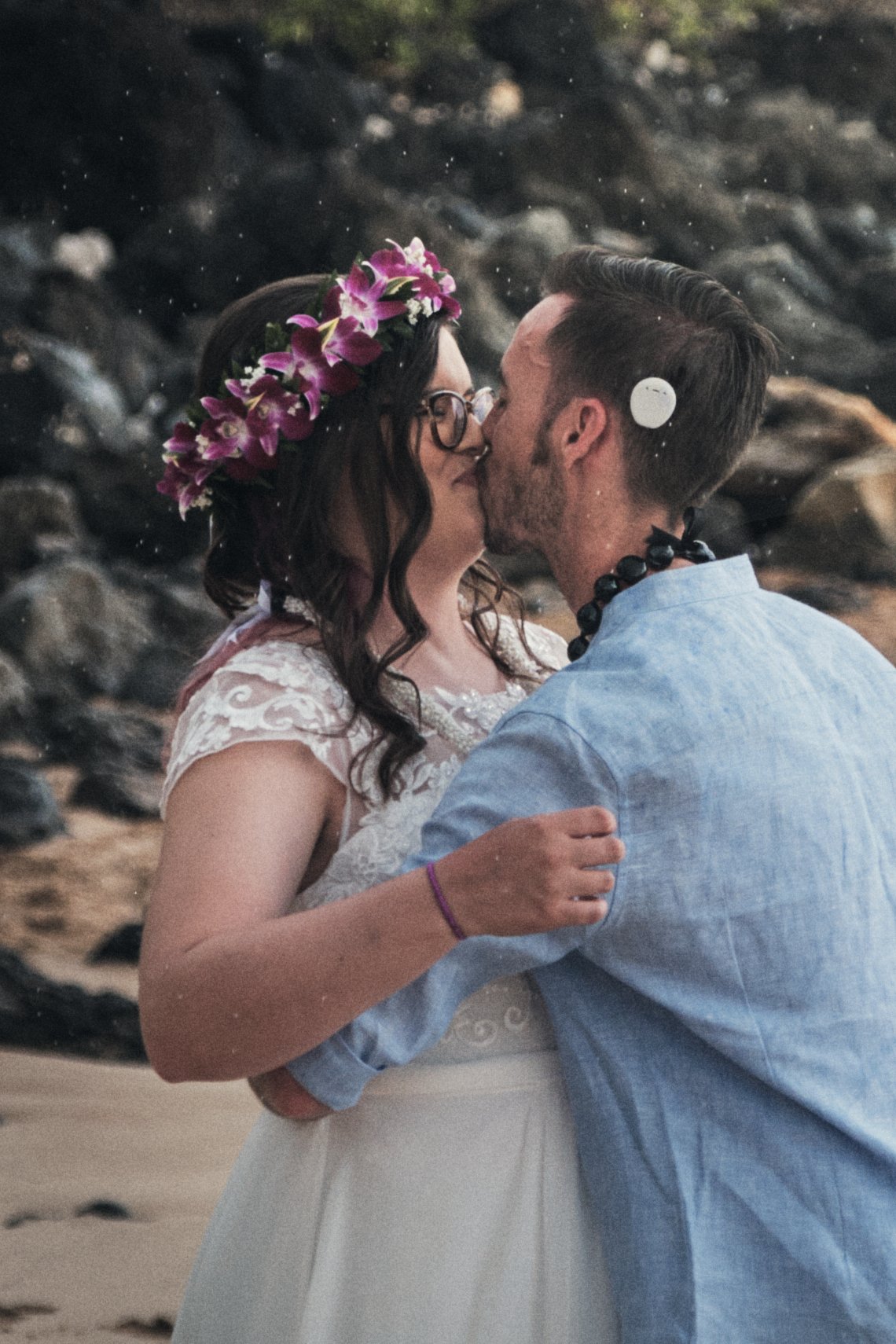 Wedding first kiss with rain falling.