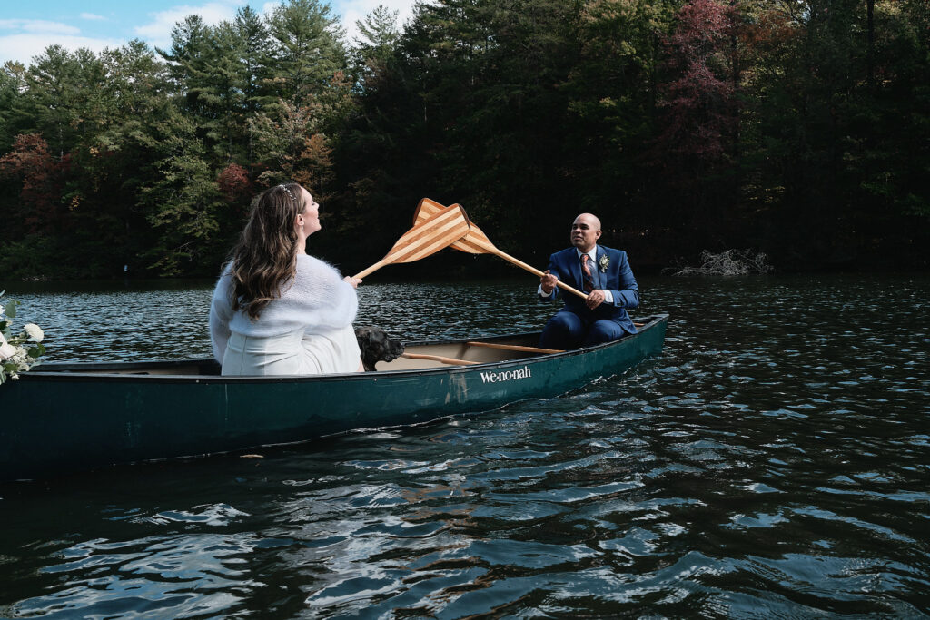 Couple touches canoe paddles during an elopement activity