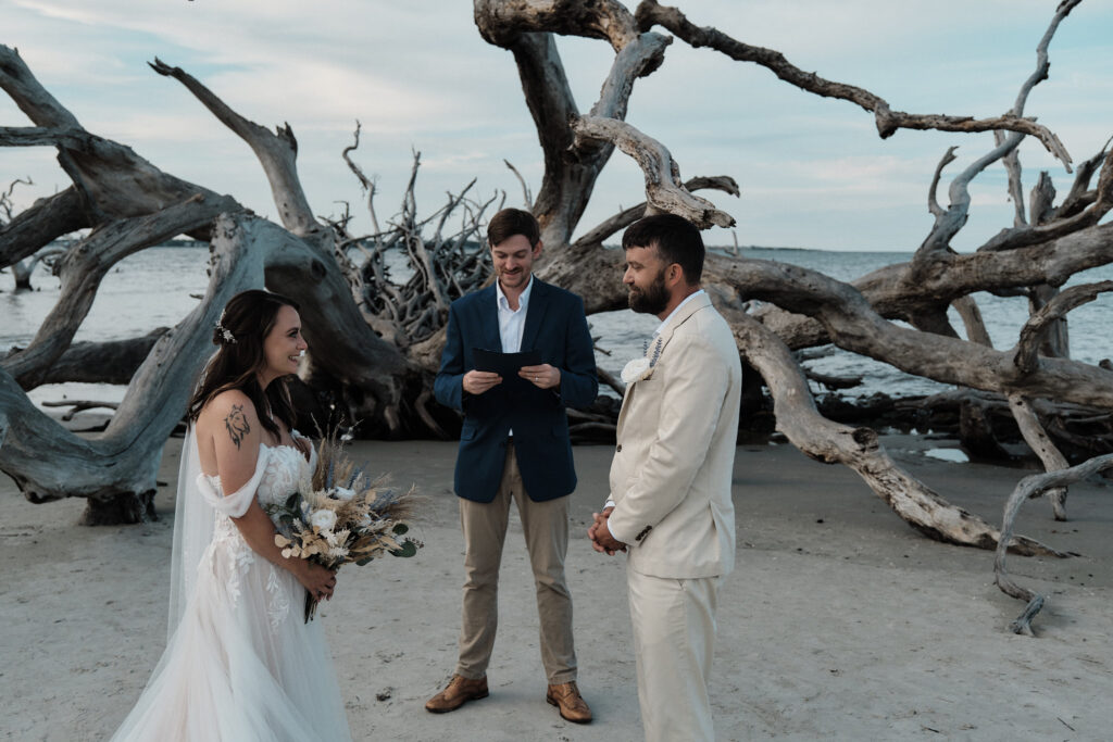 Elopement ceremony on a beach with driftwood