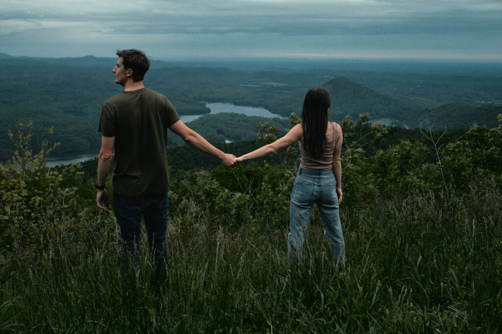 Couple holding hands looking off into the distance.