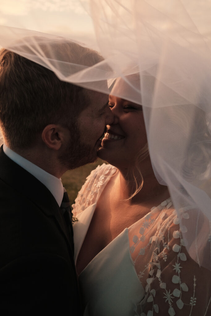 Married couple laughing and almost kissing.