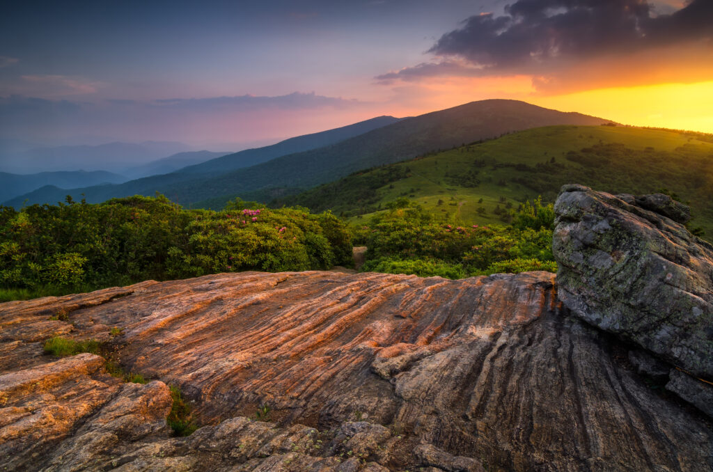 Sunset overlooking grassy mountain bald.