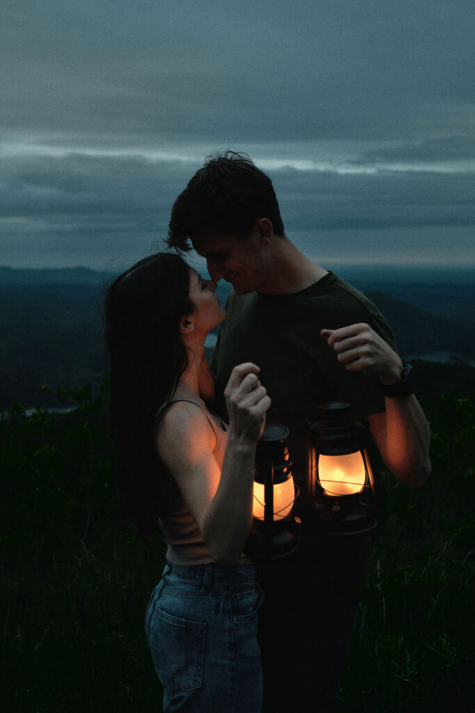 Couple holding lanterns during blue hour.