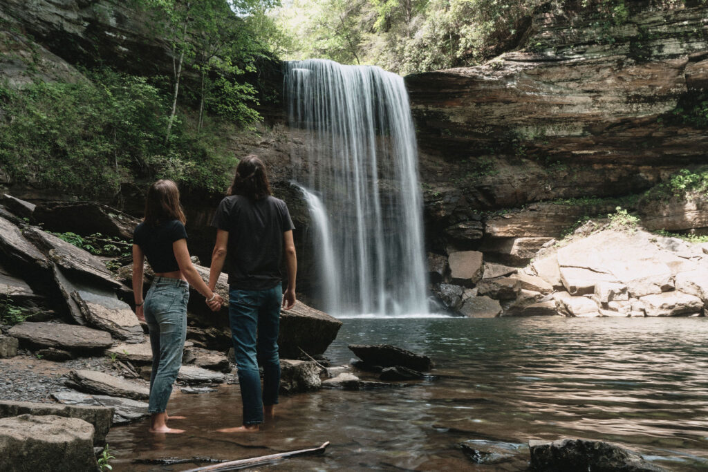 Eloping couple looking at Tennessee waterfall.