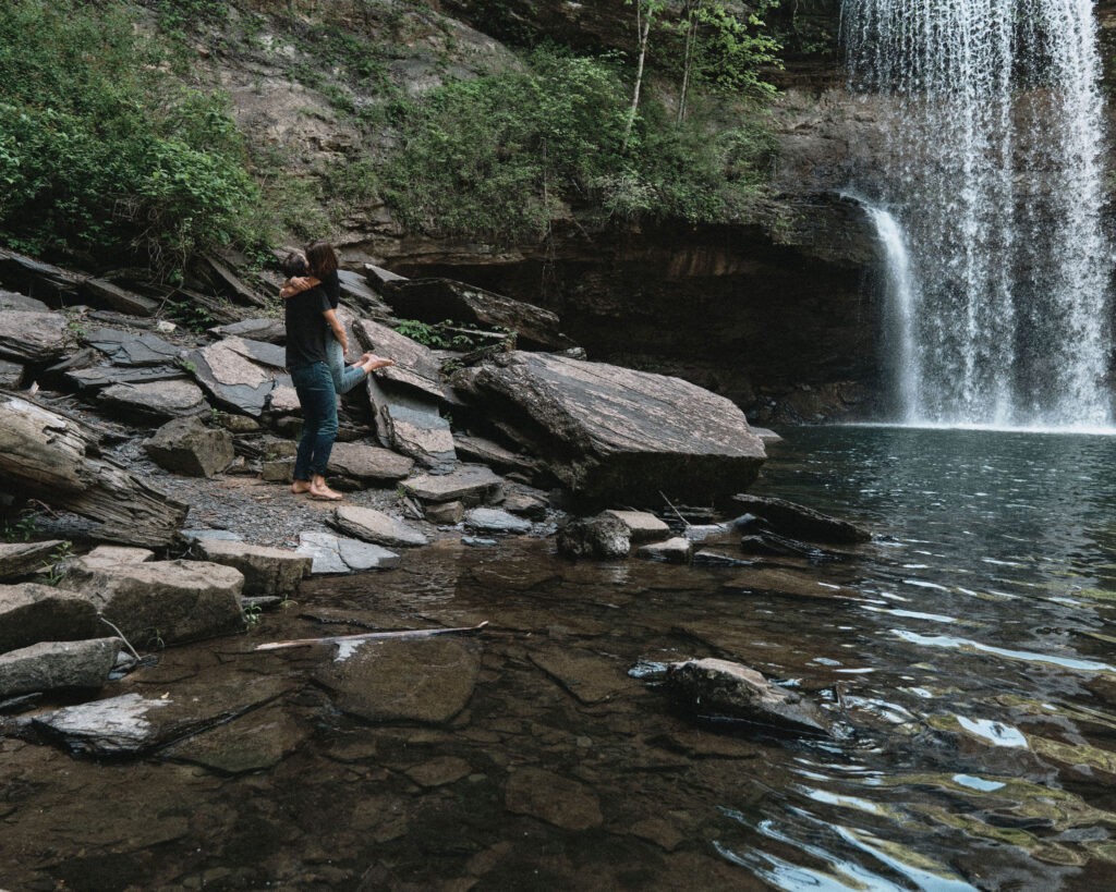 Couple embracing each other under a waterfall.