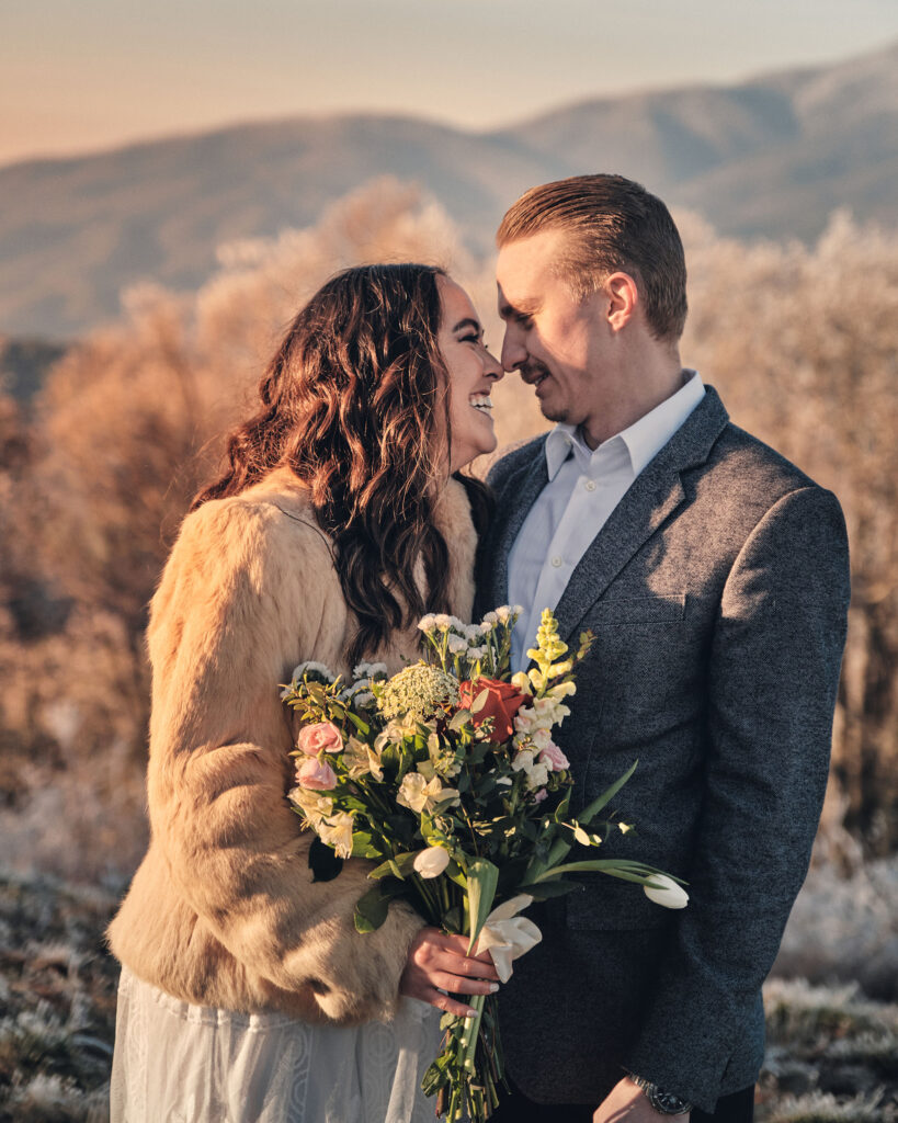 Eloping couple laughing in the winter time.