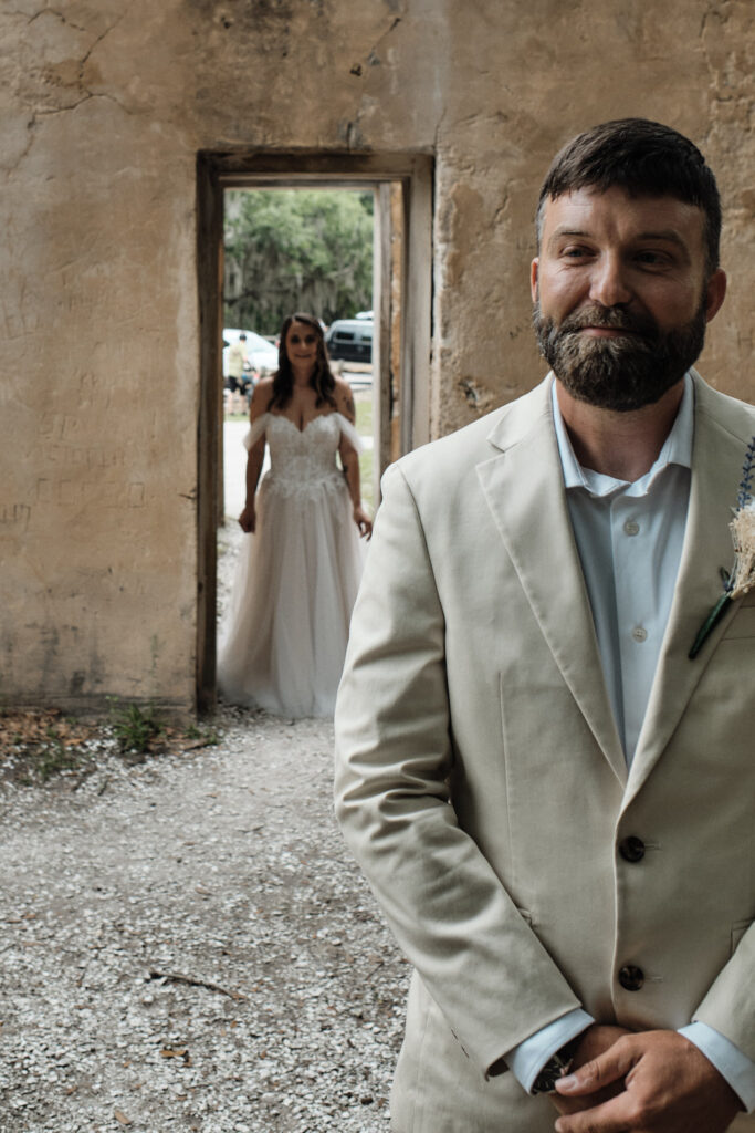 Groom smiling before seeing his bride in her wedding dress for the first time