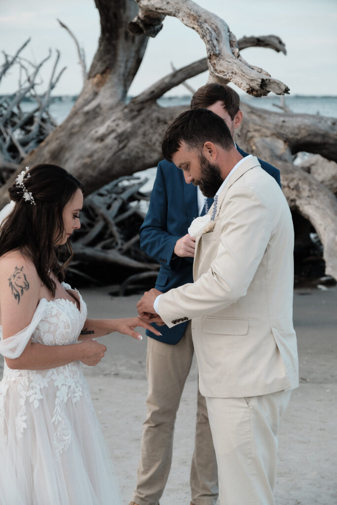 Elopement couple exchanging rings on Driftwood Beach in Jekyll Island