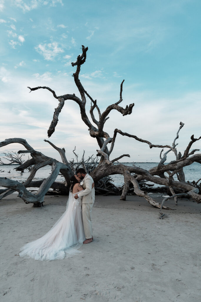 Eloping couple shares their first kiss on Driftwood Beach in Jekyll Island