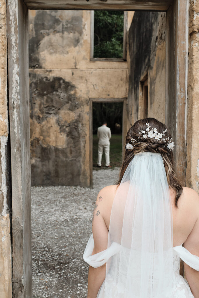 Bride looks at her groom from behind before a first look