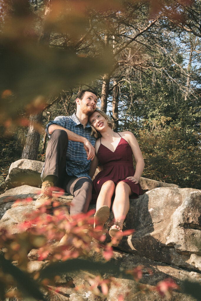 Couple sits among the fall leaves in Cloudland Canyon