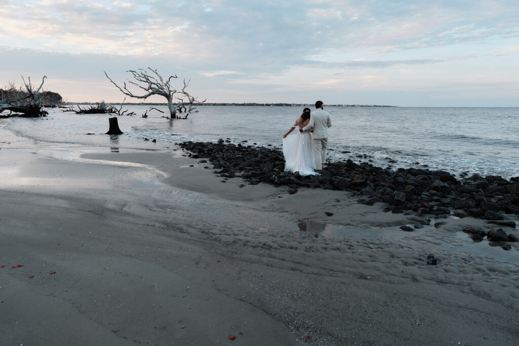 Eloping couple looks out at the ocean together