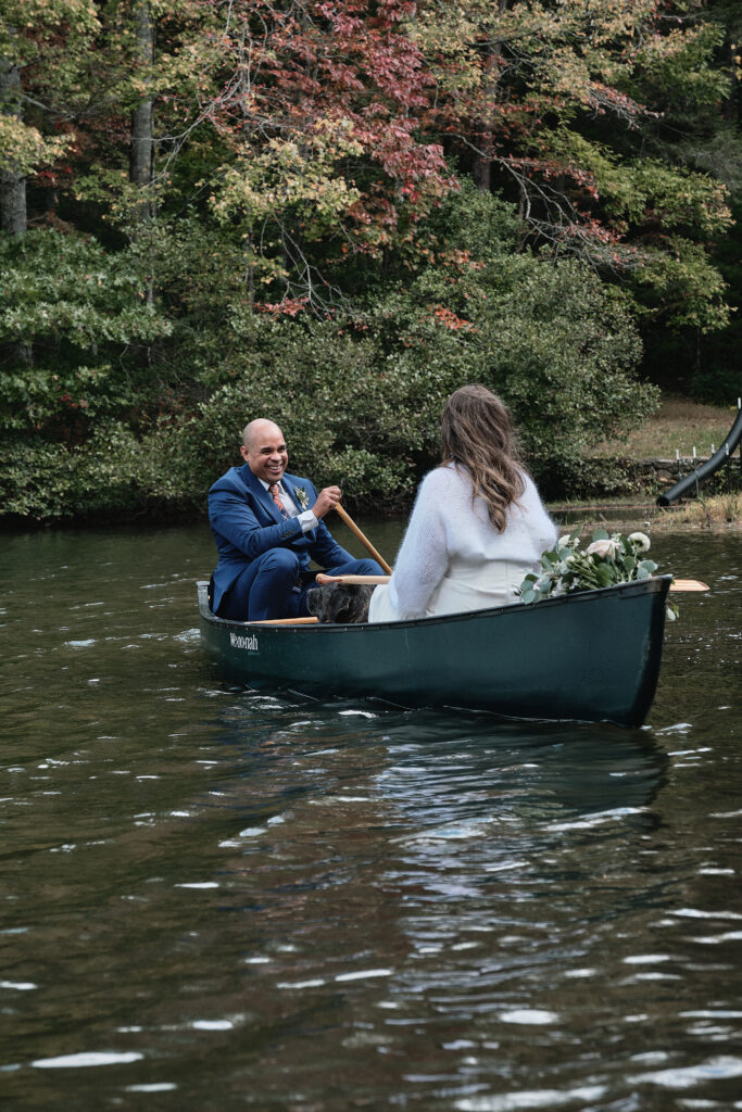 Eloping couple laughs while in a canoe together