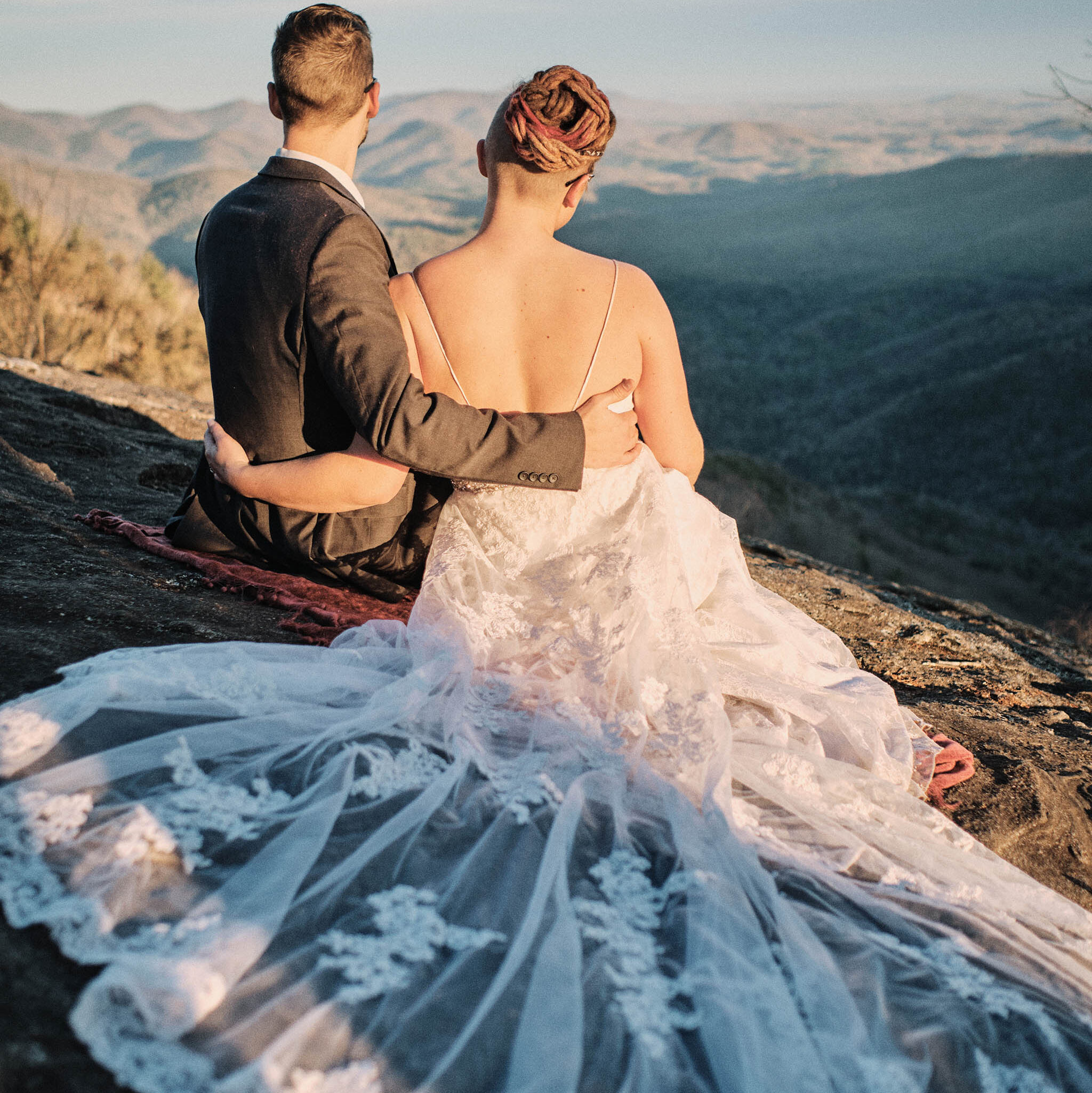 Eloping couple looks out at the sunset