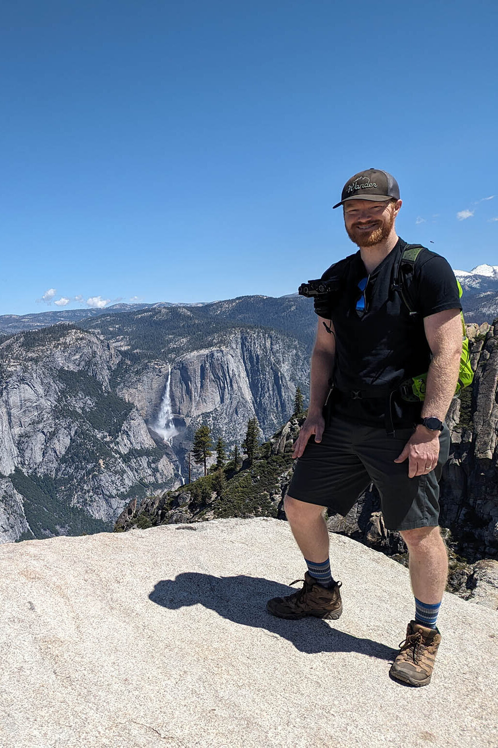 Hiking elopement photographer stands on top of a high overlook