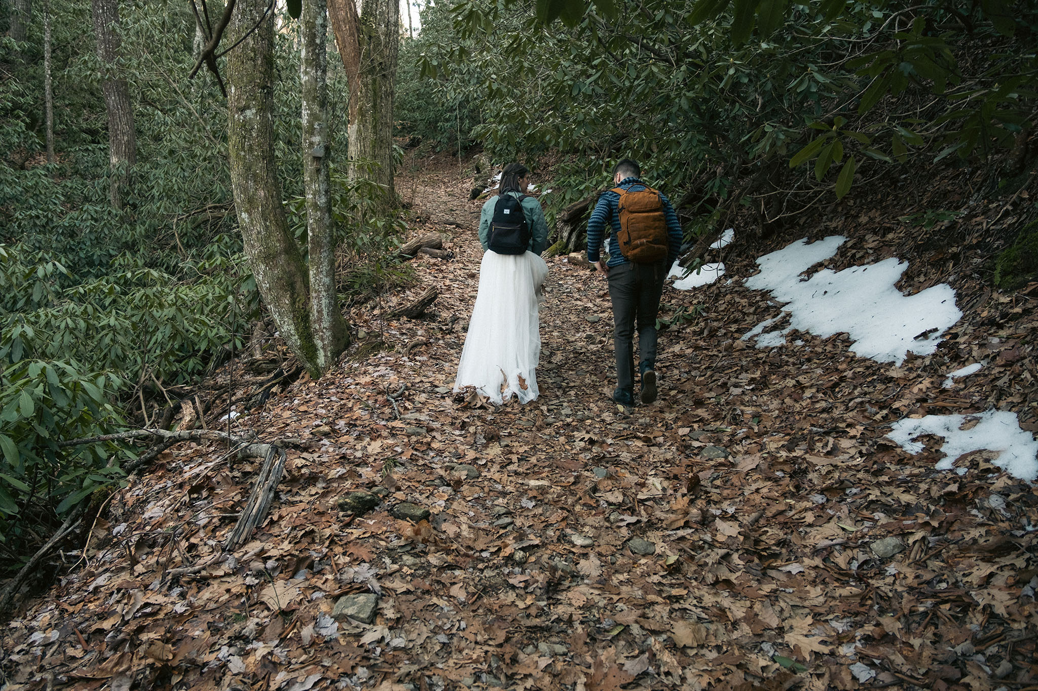Elopement couple hiking in the snow in North Carolina.