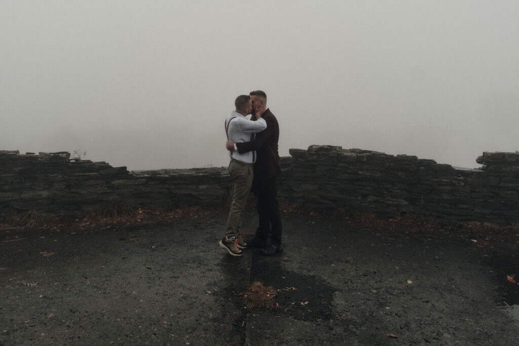 Couple shares their first kiss during a foggy elopement
