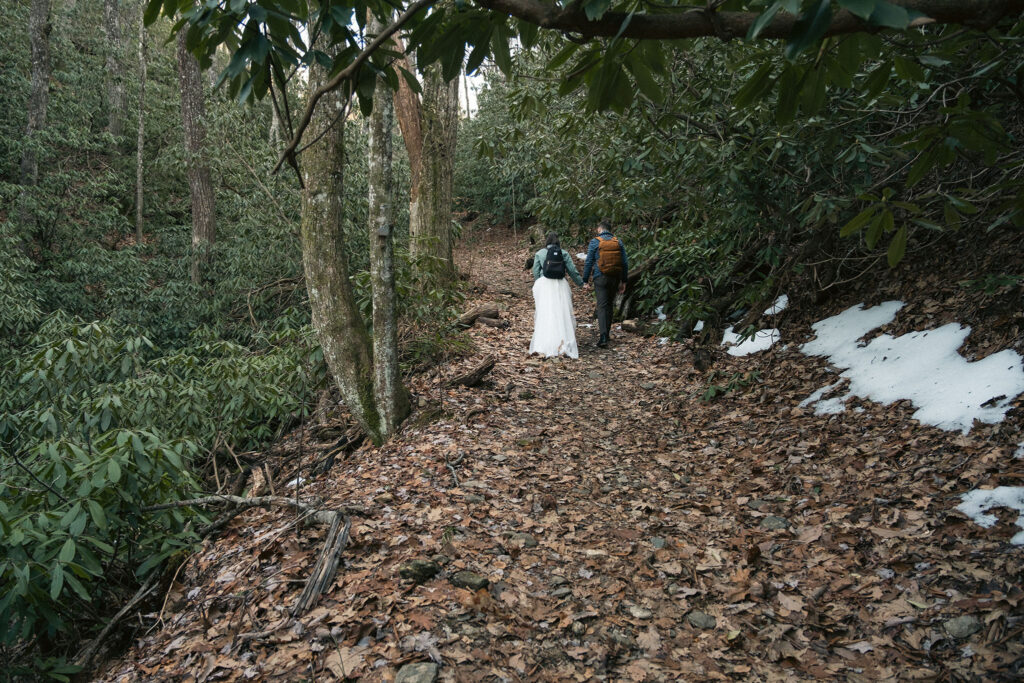 Hiking elopement couple walking through the forest