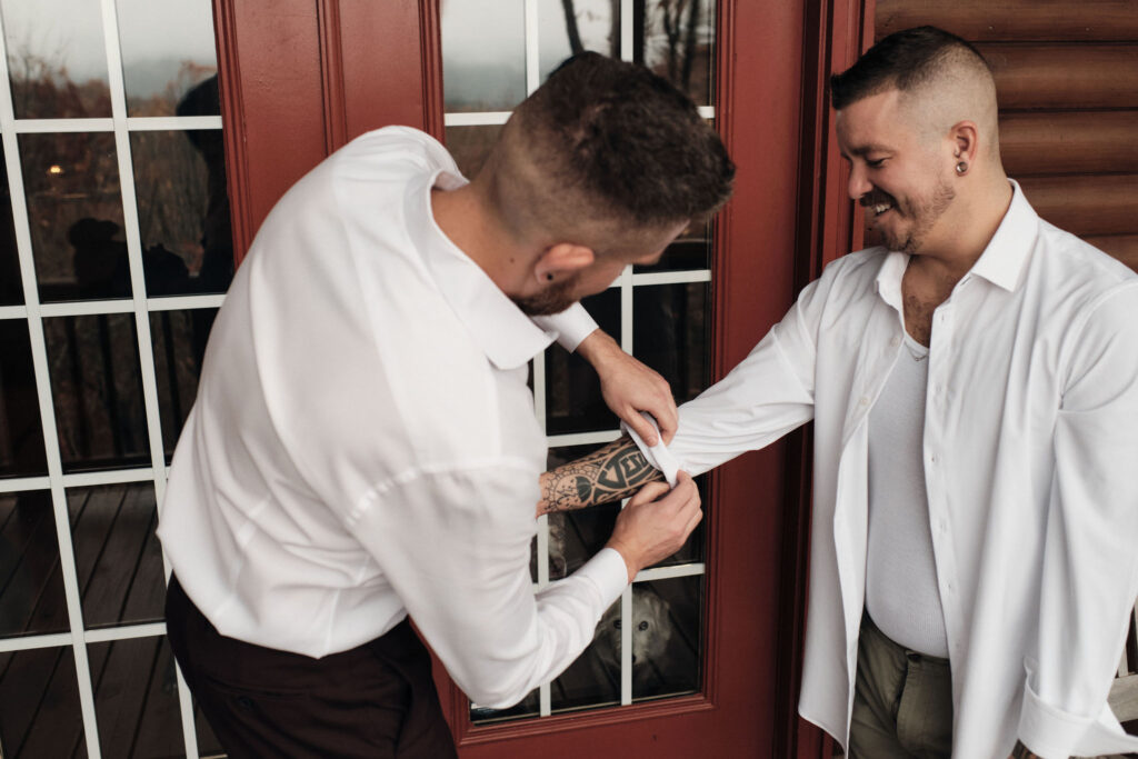 Couple helping each other get ready on their wedding day