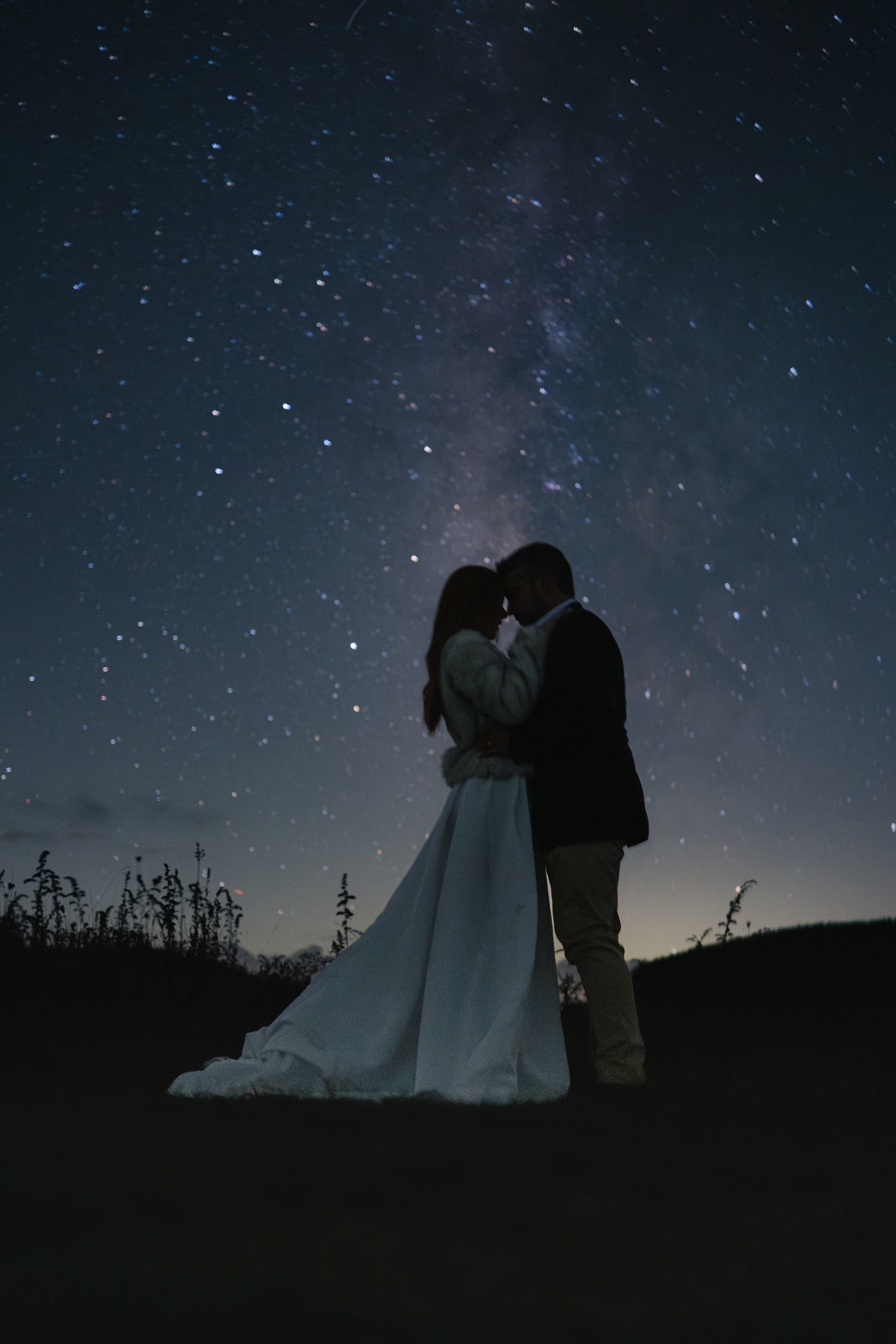 Elopement couple stands with the milky way overhead